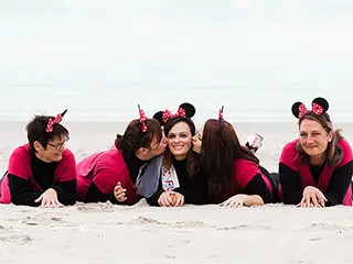 Amies proches allongées sur le sable avec des oreilles de Mickey