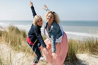 Deux femmes en équilibre joyeux sur une dune de sable