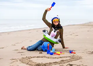 Femme jouant avec des jouets de plage, esprit enfantin et gai