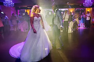 Mariés partageant leur première danse éclairés par des spots