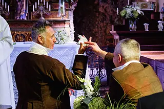 Un témoin remettant un mouchoir au marié dans une église