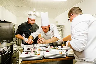 Chefs en pleine préparation de plats dans une cuisine de mariage
