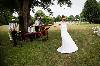 Mariée dansant devant un groupe de jazz en plein air