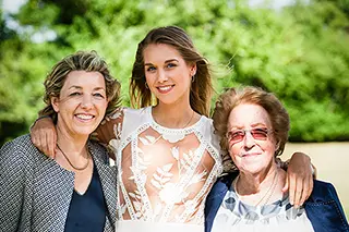 Trois générations de femmes souriantes lors d'un mariage
