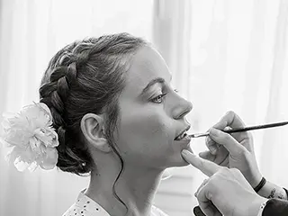Maquillage délicat appliqué sur la mariée, image en noir et blanc