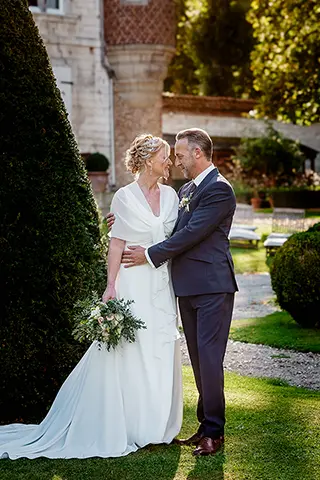 Mariés échangeant un baiser dans les jardins d'un château