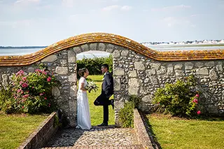 Mariés se tenant devant un mur de pierre