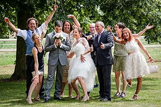 Les mariés et leurs amis levant les bras en signe de célébration