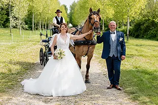 Mariés à côté d'une calèche tirée par un cheval