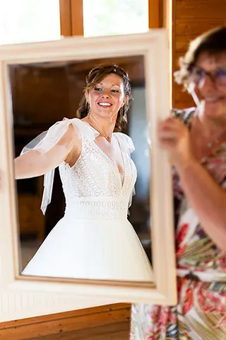 La mariée souriante se regardant dans le miroir