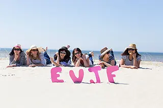 Groupe de jeunes femmes riant ensemble sur la plage de Fort Mahon pour un EVJF