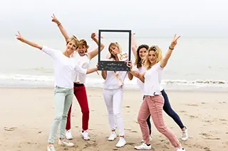 Groupe de 5 jeunes femmes célébrant un enterrement de vie de jeune fille sur la plage