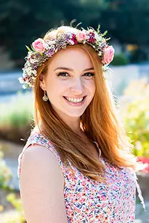 Une jeune fille souriante porte une couronne de fleurs sur la tête lors d'un enterrement de vie de jeune fille