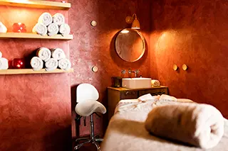 Cabine de soins relaxante avec serviettes roulées, miroir et éclairage tamisé