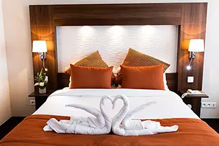 Chambre d'hôtel de luxe avec lit king-size et décorations de serviettes en forme de cygnes