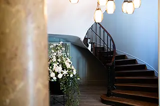 Escalier élégant avec une rampe en fer forgé et un arrangement floral dans le hall d'entrée d'un hôtel