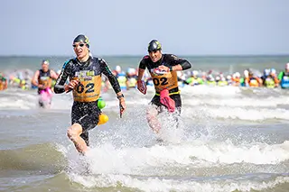 Participants en plein effort durant une course Swimrun à la plage