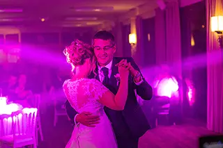 Mariés dansant sous un éclairage violet lors de leur réception de mariage