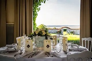 Table de mariage décorée avec une vue magnifique sur la mer à travers la fenêtre